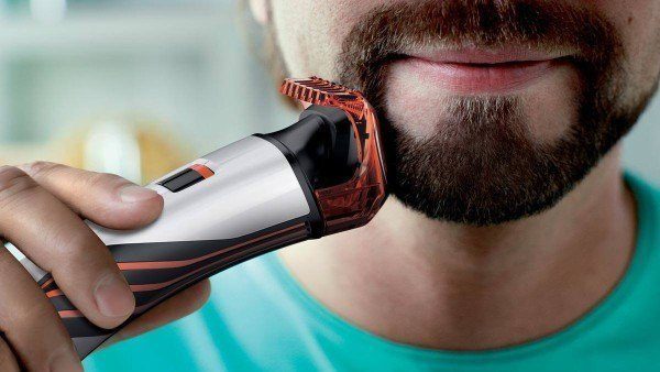 Hombre afeitarse la barba con una máquina de afeitar eléctrica
